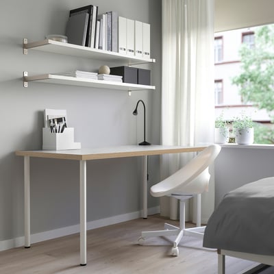 Minimalist home office with white LAGKAPTEN desk, sleek design, shelves, chair, and lamp by window.