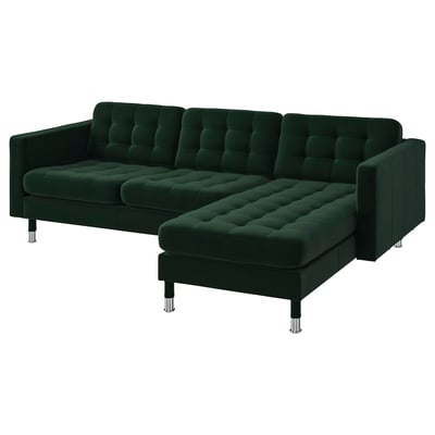 Dark green l-shaped sofa with tufted cushions and chrome legs for modern living room.