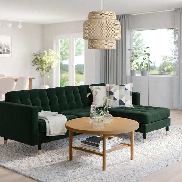 Modern living room with green skrona sofa, stylish coffee table, and large windows.