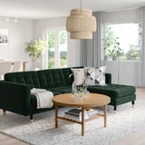 Modern living room with green skrona sofa, stylish coffee table, and large windows.