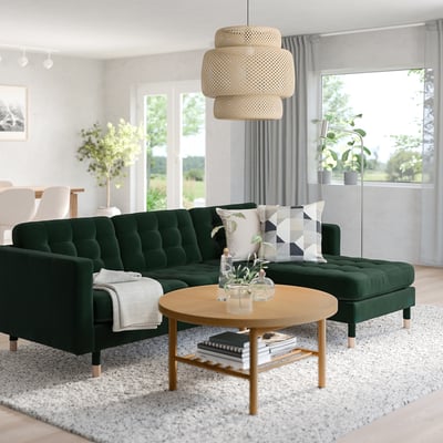 Modern living room with green skrona sofa, stylish coffee table, and large windows.