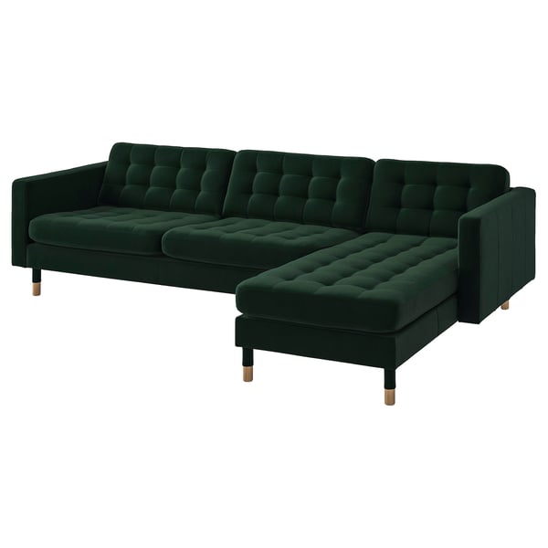 Modern dark green l-shaped sofa with plush velvet tufted cushions and wooden legs.