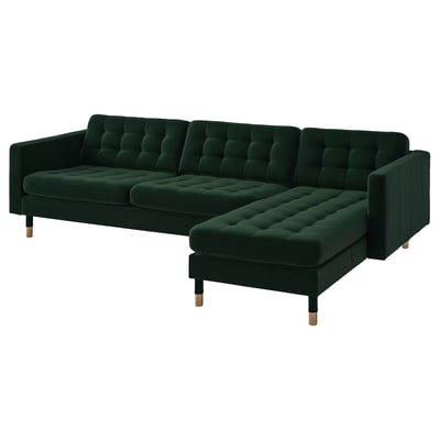 Modern dark green l-shaped sofa with plush velvet tufted cushions and wooden legs.