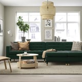 Modern living room: dark green låndeskrona sofa, large, with wooden coffee table, cushions, plant, and pendant lamp.