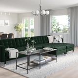 Emerald l-shaped sofa in modern living room with large windows.