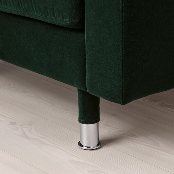 Dark green fabric upholstered furniture leg with chrome base; shows craftsmanship and stability.