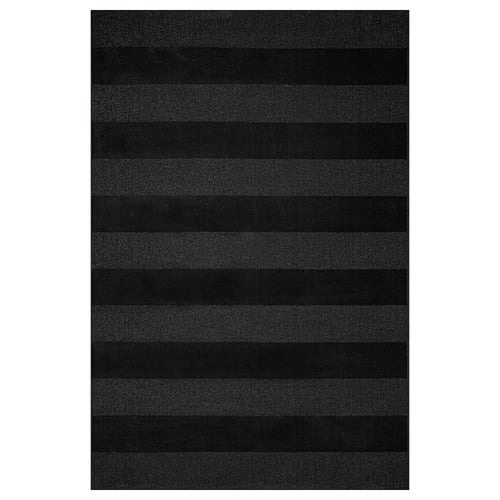Dark grey rug with curly yarn stripes for large spaces, made from recycled materials.