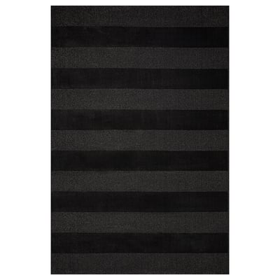 Dark grey rug with curly yarn stripes for large spaces, made from recycled materials.