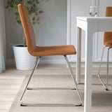 Brown upholstered chair with chrome base, near white table