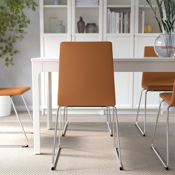 Modern dining chair with brown padded seat and chrome base, designed for comfort and durability.