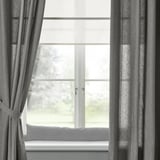 Gray LJUNGSNÄRJA curtains on large window with tree view.