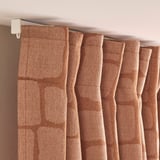 Rich brown curtains with intricate weave hang neatly, blocking light and adding elegance.