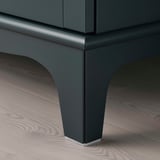Sleek, modern cabinet with tapered legs, dark green finish, high-quality materials.