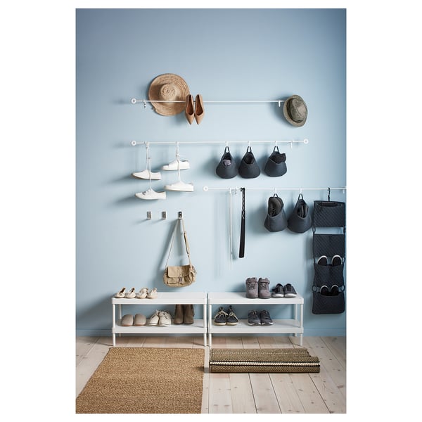 MACKAPÄR hallway organization: shoe racks, hanging baskets, and bags on blue wall.