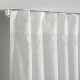 White curtains with subtle grid pattern hang from a white curtain rod, designed to diffuse daylight and offer privacy.