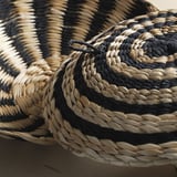 Handwoven basket with bold stripes. Dark blue and natural tones. Detailed, high-quality craftsmanship.