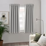 Gray recycled polyester curtain blocks light by window, with couch & lamp.