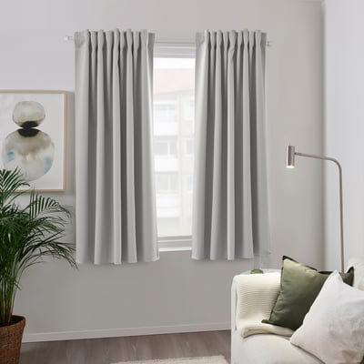 Gray recycled polyester curtain blocks light by window, with couch & lamp.
