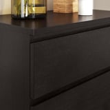 Modern black wooden chest with clean, sleek lines. Topped with stylish decor items.