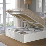 Bed with storage: flip-up base reveals organized items. Light-colored, by window, with headboard.