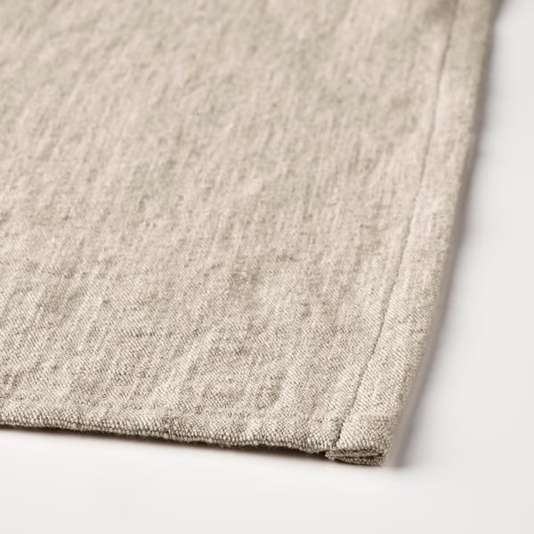 Close-up of beige aprons stitched edge, showcasing its soft, woven cotton-linen fabric.