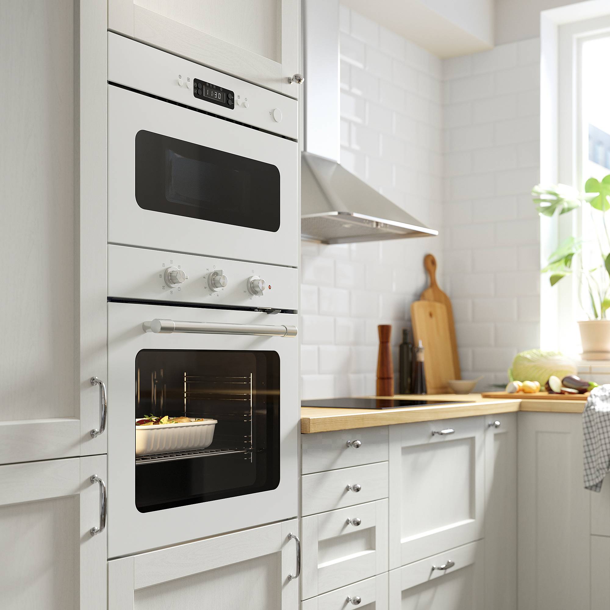 Small white modern oven with digital display, cooking a casserole, installed between kitchen cabinets.