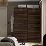 Bedroom with large dark brown MEHAMN wardrobe, sliding doors, grey bed, hanging clothes, basket.