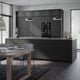 Modern kitchen with black cabinets, stainless appliances, wooden table, and hanging lights.