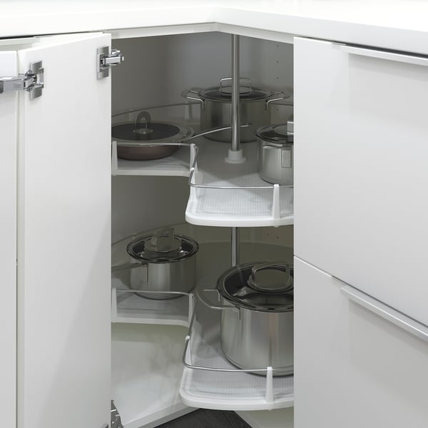 Open white kitchen cabinet with rotating shelves holding pots and pans. Efficient storage solution.