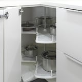 Open white kitchen cabinet with rotating shelves holding pots and pans. Efficient storage solution.
