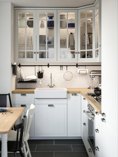 METOD white kitchen cabinet with glass door open, modern design.