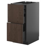 An open METOD kitchen cabinet with dark brown sinarp oak veneer drawers. The cabinet has a sleek, modern design with a smooth gray finish.