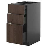 Modern kitchen cabinet with dark brown wood grain drawers, sleek handles, and black sides. Three pull-out drawers, part of the METOD system.