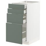 Modern kitchen unit with grey-green drawers, metal runners, and white cabinet.