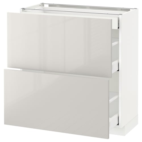Displays a white, modern kitchen cabinet from the ikea METOD series, featuring sleek, high-gloss surfaces and multiple drawers.