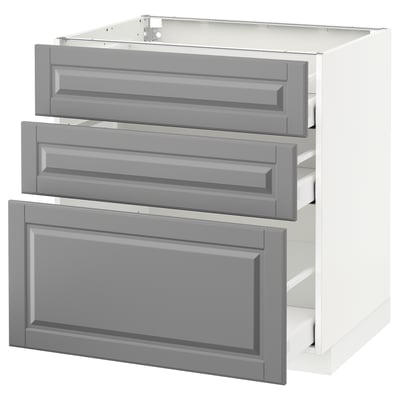 A white METOD kitchen cabinet with three grey bodbyn drawers, featuring a traditional design with beveled edges.