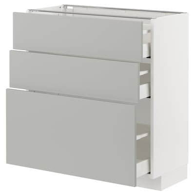 A white METOD kitchen cabinet with three light grey drawers. It a modern, clean design with a rectangular shape.
