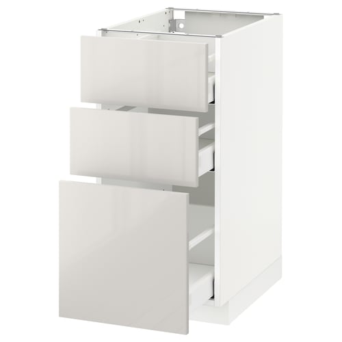 A white METOD kitchen cabinet with three open drawers, featuring a sleek, modern design with smooth, high-gloss finishes.
