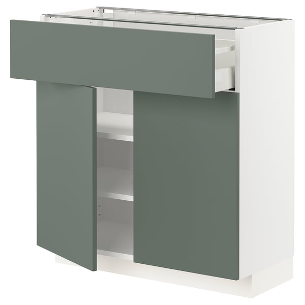 A modern IKEA METOD kitchen unit in grey-green and white with open shelves and drawers.