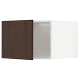 A dark brown wooden cabinet door attached to a white fridge/freezer top cabinet.
