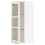Off-white METOD kitchen cabinet with glass doors, bevelled edges, nickel hinges, and glass shelves.