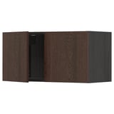Dark brown wooden kitchen cabinet with closed door and visible hinge.