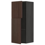 A dark brown METOD kitchen wall cabinet with two doors and an adjustable shelf. It has a sturdy frame and oak veneer finish.