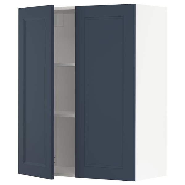 Dark blue kitchen cabinet with one open door showing a shelf inside.