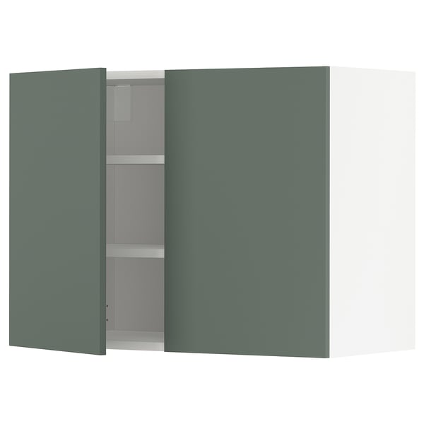 A modern wall cabinet in gray-green, featuring one open door and empty shelves.