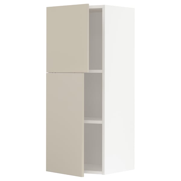 A beige METOD kitchen cabinet with two open sections. Its tall, rectangular, and modern in design, featuring a smooth finish.