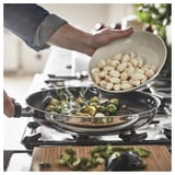 Adding gnocchi to brussels sprouts in frying pan.
