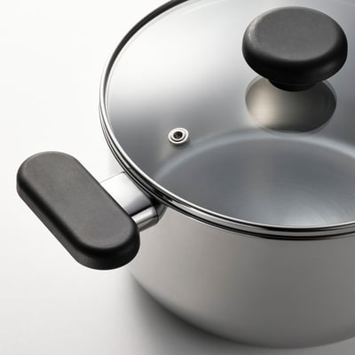 Polished silver saucepan with black grips and glass lid.