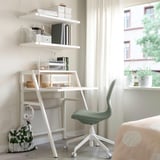 Home office with MITTPLAN white desk, green chair, shelves, and window view.