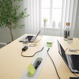 Modern conference table with integrated power outlets and cable management, ideal for meetings and collaborative work.